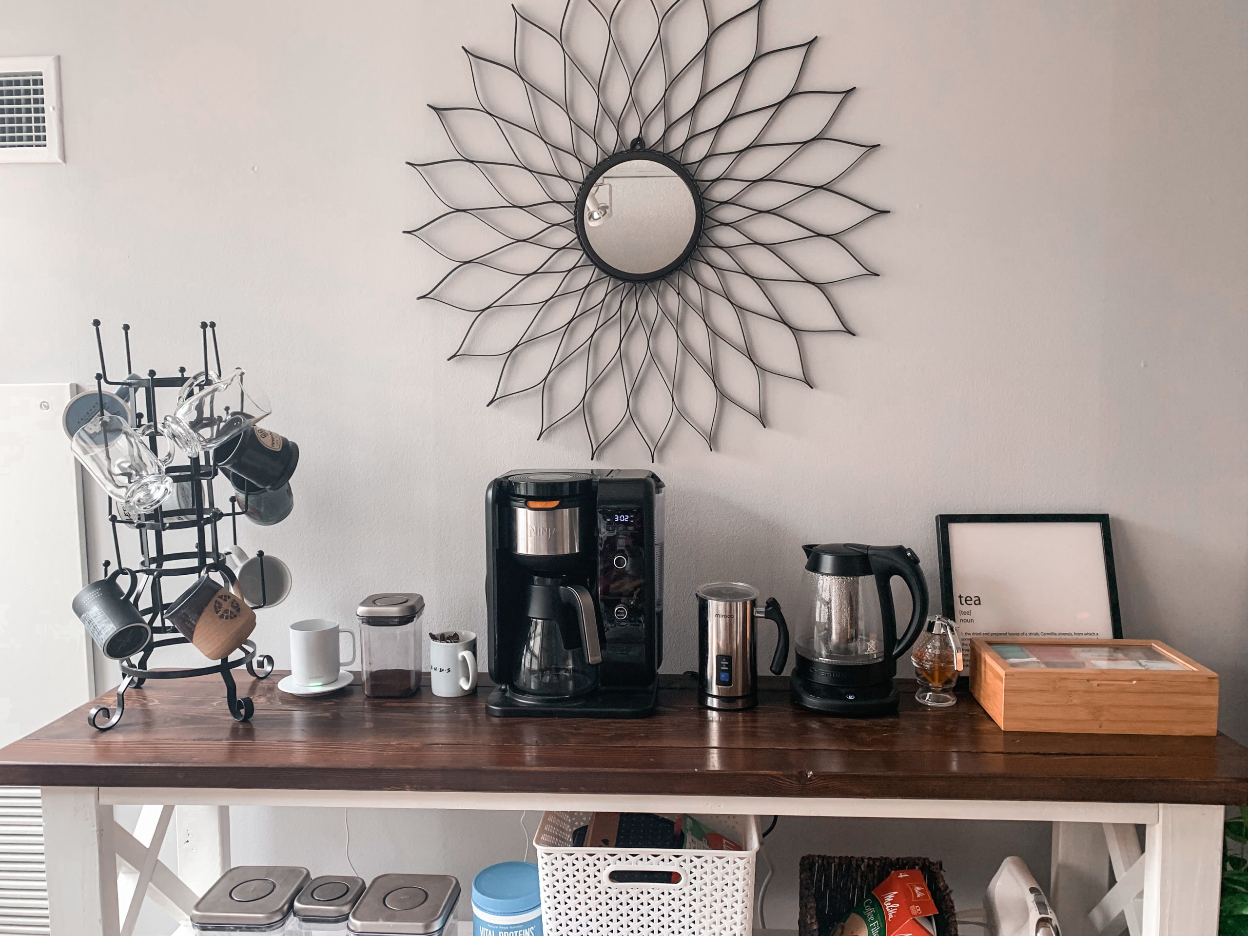 Coffee bar with coffee maker, tea kettle, milk frother, and mug tree.
